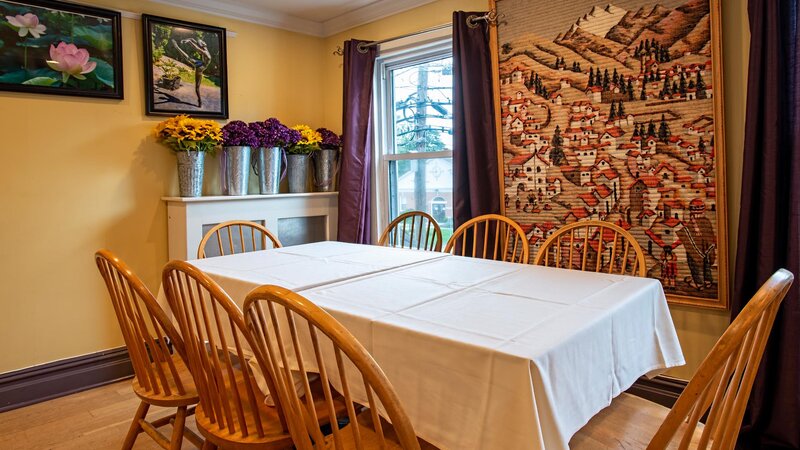 Dining room with table set for eight with flower and painting decorations